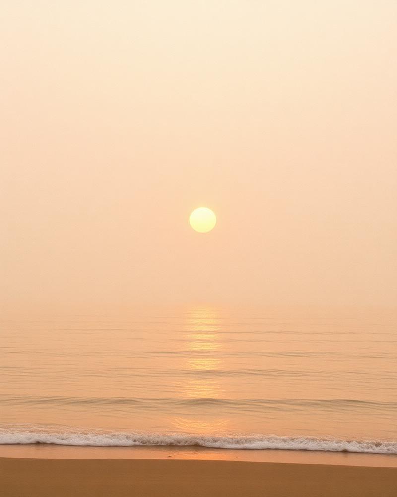 Golden sun low over calm ocean water